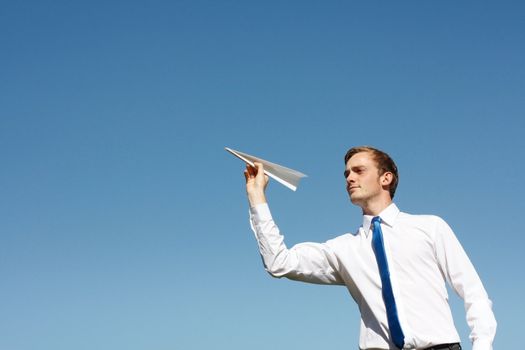 A business man throwing a paper plane