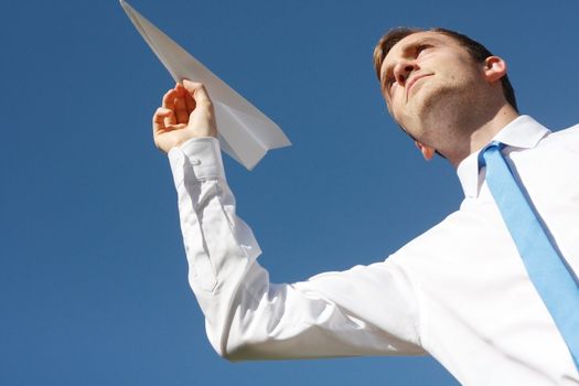 A business man throwing a paper plane