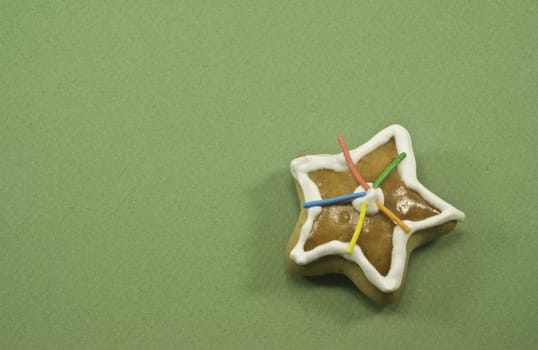 Single decorated star cookie on green paper with copy space on left