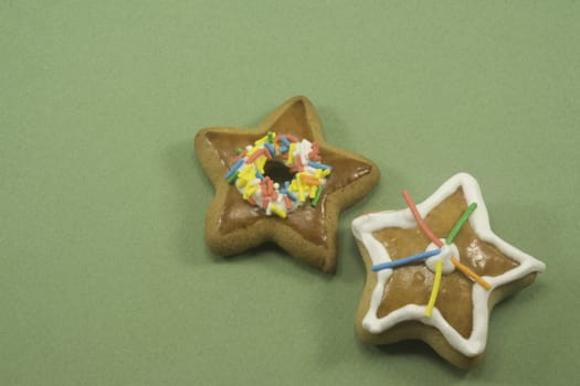 Two star Christmas cookies on green paper