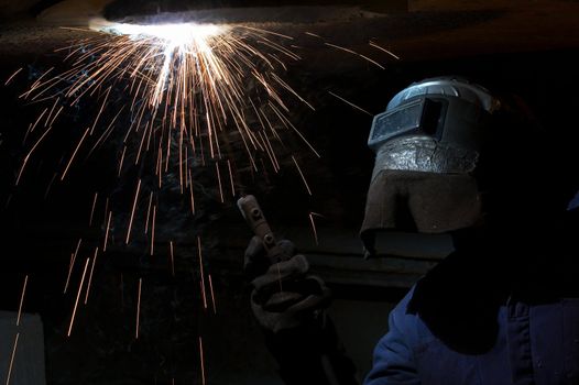 a welder working at shipyard at night
