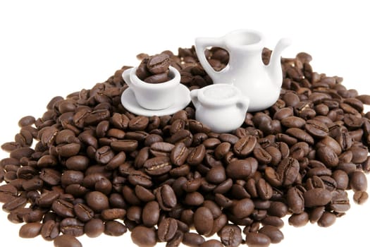 Stack of coffe beans with miniature coffee service