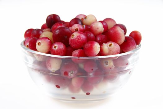 Close-up of fresh cranberry in glass dish on white background