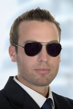 young american businessman with sunglasses
 on an abstract  background