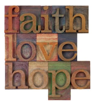 biblical, spiritual  or metaphysical reminder - faith, hope and love in old wooden letterpress type blocks, stained by colorful inks, isolated on white