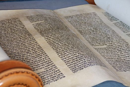 The hebrew Torah, displayed here on a synagogue alter, is hand written on goat skin parchement by a specially trained scribe using a feather quill