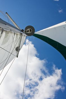Sails, GPS and radar of a catamaran boat with a deep blue sky and white cloud