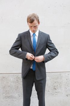A business man adjusting his suit