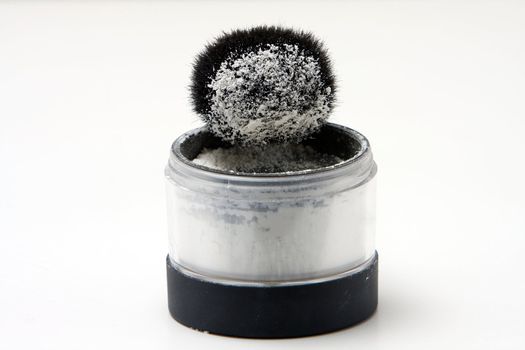 Translucent white powder in a jar and on brush, isolated