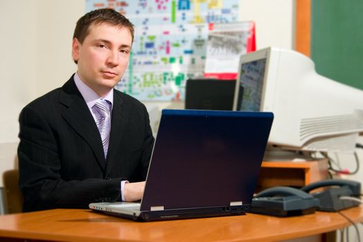 Men working at laptop and desktop at his work place