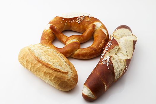one pretzel, one roll and one sort of pretzel on white background