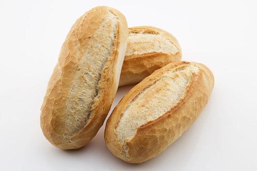 three baked breakfast rolls on white background
