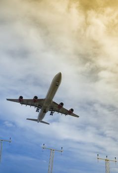 passenger jet on takeoff or landing through color gradient clouds