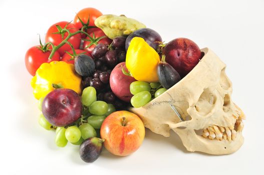 A human skull overflowing with fruits and vegetables, from above.