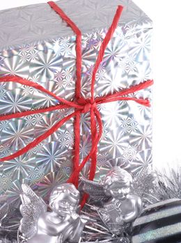 In silver wrapped christmas present with christmas ornaments.