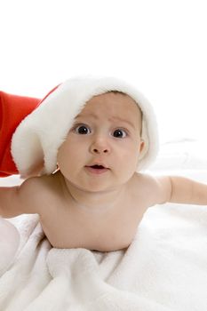 cute baby lying with santa cap against white background