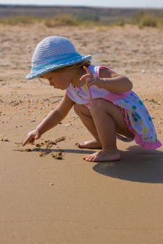 people series: little girl draw on the sand