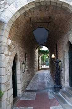 A empty alley way leading to a courtyard in an old European town