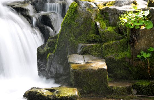 Beautiful waterfall over natural rocks summer time