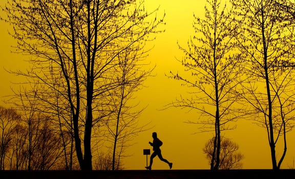 A running man silhouette in golden background