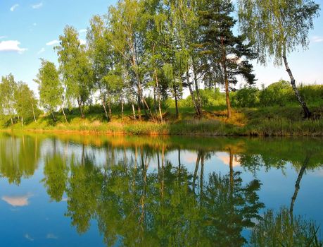 Picturesque spring landscape of river and bright trees and bushes