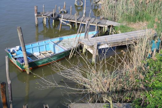 blue and wooden rowboat parked in a river