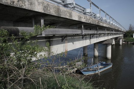 long bridge acrossing a river whit a little boat