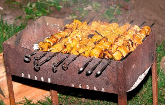 Preparing hot shish kebab on skewers. Shallow DOF
