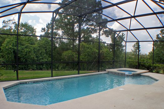 A swimming pool and spa with a conservation view.