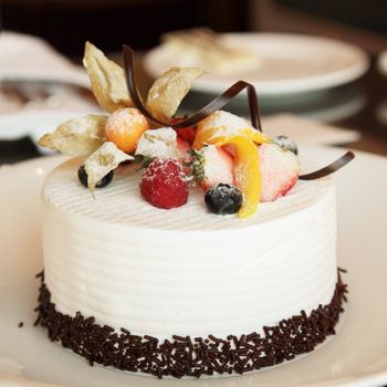 White Cream Icing Cake with Fruits and Chocolate