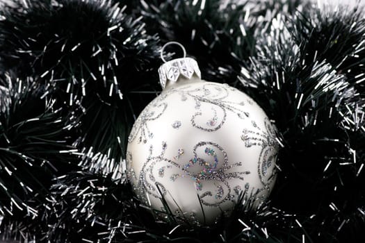 White Christmas bauble in green tinsel