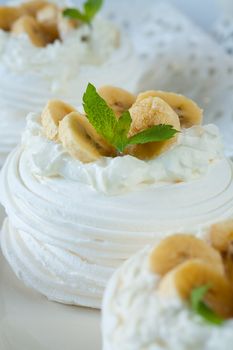 Meringue cake with sliced banana and peppermint leaf