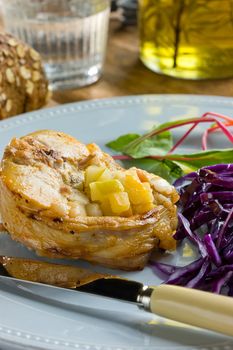 Pork medallions with red cabbage, bread, fork and knife