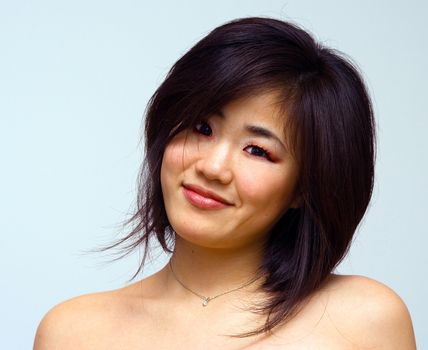 Beautiful sexy Oriental woman with bare shoulders laughing