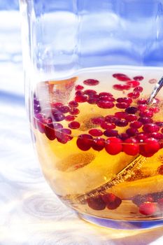 Compote with cranberry and pineapple in glass jug