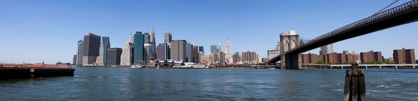 Panorama of the Financial District in Manhattan, New York City, under a deep blue sky on a bright sunny day. View from Fulton Ferry Landing in Brooklyn.