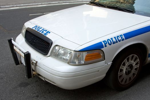 Front and side view of a white police car with blue letters saying 'police'.