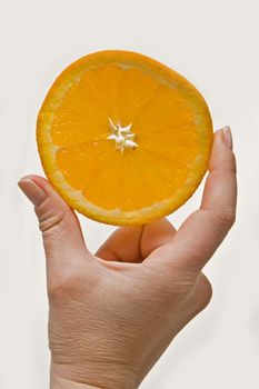 Woman hand holding up an orange, tangerine of mandarin wedge, isolated on white