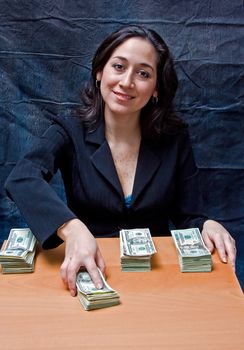 Happy smiling business woman paying ourt money isolated on a dark background