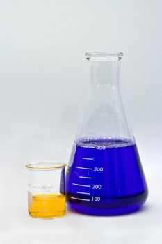 Flask and beaker with colorful liquids as pH indicators on a white background