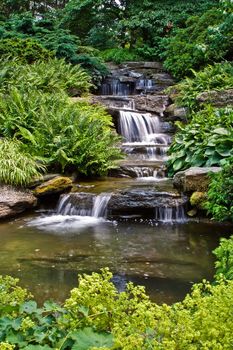 Beautiful multi-layered waterfall between vegetation.