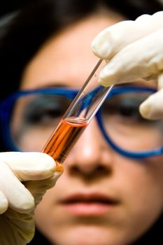 Scientist is checking the color change of a reaction in a test tube