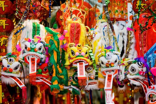 Colorfull Chinese lunar new year's dragons hanging in front of a store with good fortune quotes.