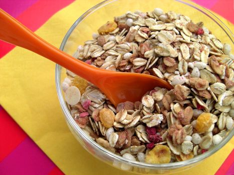 orange spoon in a bow of muesli