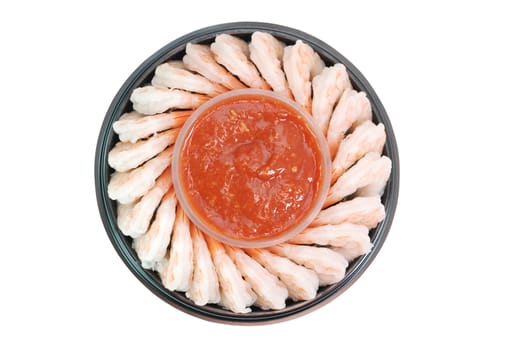 Shrimp cocktail arranged around a cup of seafood sauce.  Isolated on white background with clipping path.