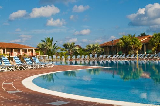 Resort swimming pool under a clear tropical sky.