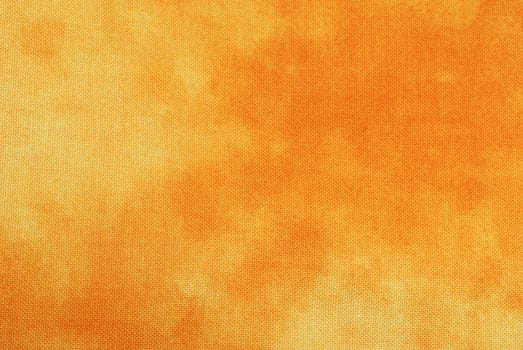 Macro of orange tye-dyed fabric for background use. 