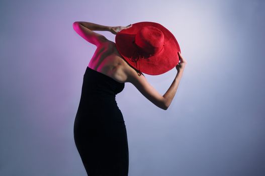 Portrait of young elegant woman wearing black dress and hat 