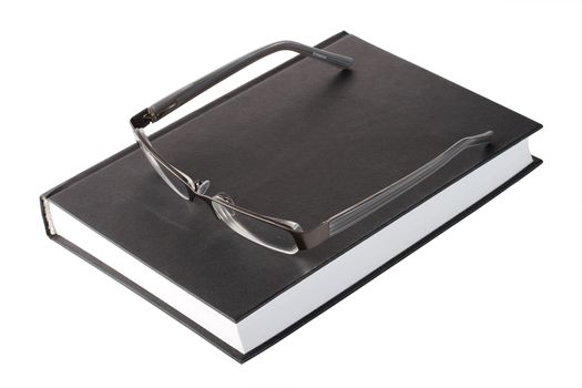 glasses on a black book, isolated on white