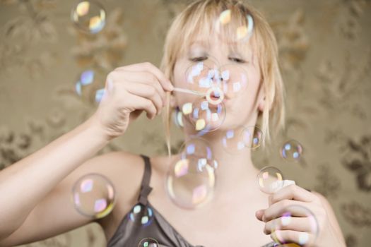 Pretty young girl with blue eyes blowing bubbles